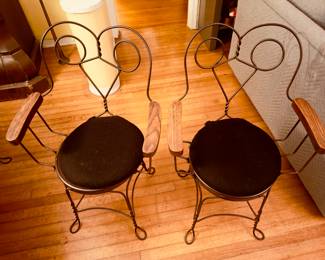 Set of four vintage ice cream parlor chairs with wooden armrests and black cushions. Excellent condition. 