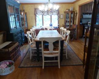 Rustic farmhouse dining table with 8 chairs, painted green breakfront, curio cabinets
