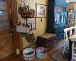 Rustic farmhouse dining table with 8 chairs, painted green breakfront, curio cabinets, baskets & holder