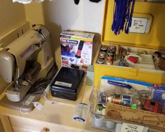 Elna sewing machine with attachments and two sewing boxes.