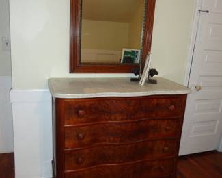 Burl Mahogany Serpentine Front w/ 4 drawers and a marble top.  Beautiful vintage mirror on the wall.