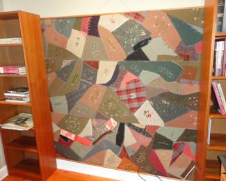 Very old patchwork quilt mounted on a wall board