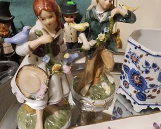 pair of vintage hand-painted porcelain figurines of a boy and girl with birds. 