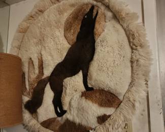 handmade round alpaca fur rug featuring a wolf howling at the moon design. 