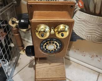 vintage replica wall-mounted oak telephone, designed to look like an antique crank phone but featuring modern push-button dialing within the rotary dial face. 