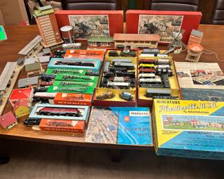 A huge assortment of vintage HO train scale accessories German made Marklin & Faller model railroad accessories. Included train sets, kits, approximately 40+ buildings (not all shown), the ESSO Sky Srapper, train station, and alot more…