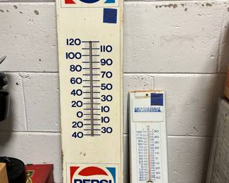 Tall Pepsi thermometer and an American Family thermometer.