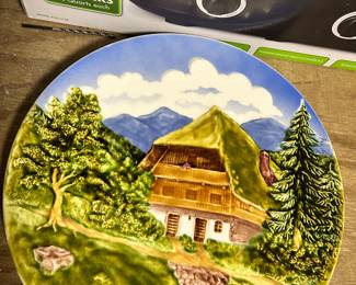 ~14" German Majolica hand painted wall plate with a raised relief scene of a mountain chalet.