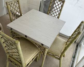 Vintage rattan fold-out game table with four chairs.