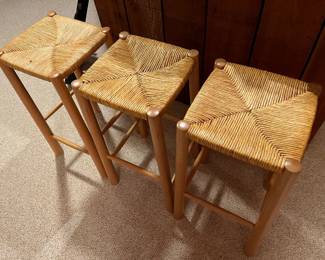 Three matching wood and rush bar stools.
