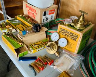 Table filled with new in boxes welding supplies many Victorian brand