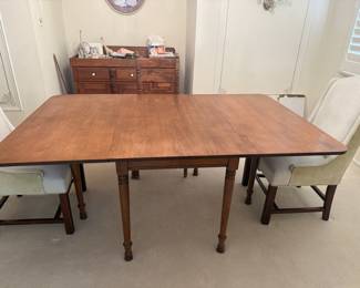 Tall CityChair Co. gate leg table with several leaves and cover.