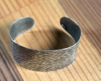 This lot features a cuff bracelet by designer, Marjorie Baer. Signed as shown in photos and measures, 7”.

