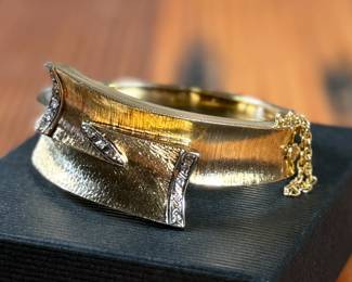 This lot features an incredible hand made 18k gold & diamond Art-Deco bangle bracelet with an integrated box clasp and safety chain. Accompanied with an appraisal from Reliant Gem Lab, this bracelet has a total approx. weight of 41.71 grams and .23 ct of thirteen (13) bead set single cut diamonds. 

