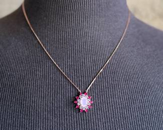 This lot features a stunning rose gold colored silver quartz and ruby pendant necklace with a chain extender. Measures at 20”, marked 925, and has a total approx. weight of 4.59 grams.

