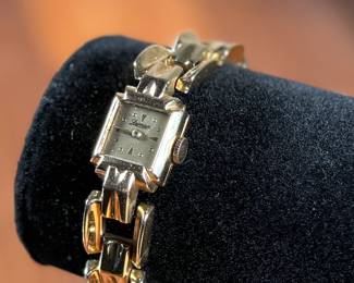 This lot features a 14k gold Leman watch with a total approx. weight of 28.5 grams. The watch is accompanied with an appraisal, is a manual wind with a 17-jewel Pathe Watch Co. movement, and runs/sets fine with safety clasp. The watch is 6.5” in length.

