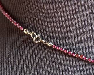 This lot features a vintage garnet beaded necklace with a sterling silver pendant containing a single garnet stone. This necklace measures, 17”.

