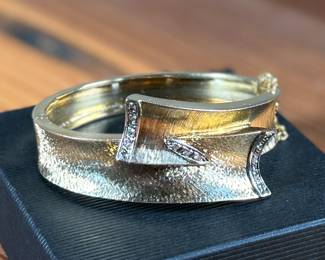 This lot features an incredible hand made 18k gold & diamond Art-Deco bangle bracelet with an integrated box clasp and safety chain. Accompanied with an appraisal from Reliant Gem Lab, this bracelet has a total approx. weight of 41.71 grams and .23 ct of thirteen (13) bead set single cut diamonds. 

