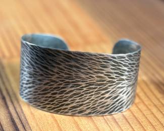 This lot features a cuff bracelet by designer, Marjorie Baer. Signed as shown in photos and measures, 7”.

