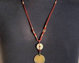 This lot features a Chinese necklace with red coral beads & coins. The necklace measures, 26”.

