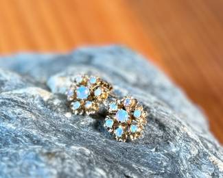 This lot features a pair of stunning 14k gold earrings, each containing seven (7) opals, circa 1940s. Total approx. weight of 2.58 grams.

