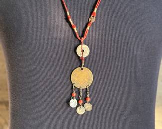 This lot features a Chinese necklace with red coral beads & coins. The necklace measures, 26”.

