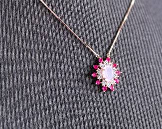 This lot features a stunning rose gold colored silver quartz and ruby pendant necklace with a chain extender. Measures at 20”, marked 925, and has a total approx. weight of 4.59 grams.

