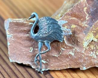 This lot features a hand made "flamingo" pin that measures 1.75” tall and crafted from sterling silver.

