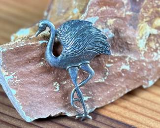 This lot features a hand made "flamingo" pin that measures 1.75” tall and crafted from sterling silver.

