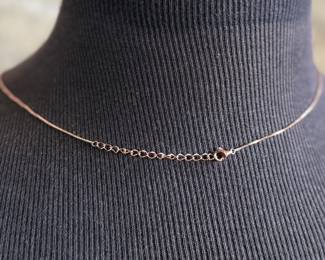 This lot features a stunning rose gold colored silver quartz and ruby pendant necklace with a chain extender. Measures at 20”, marked 925, and has a total approx. weight of 4.59 grams.

