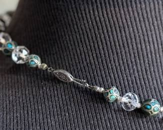 This lot features a beautiful necklace crafted from glass, turquoise, and sterling silver that measures, 18”.

