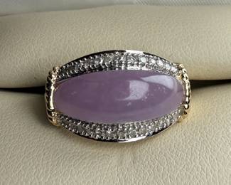 This lot features a 14k gold ring with lavender jadeite and genuine diamonds. The jadeite measures 17.7mm x 7.7mm and is set between two rows of single point diamonds. This ring comes in a size 7 with a total approx. weight of 4.42 grams.

