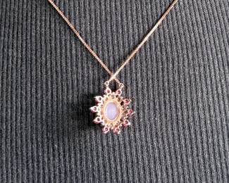 This lot features a stunning rose gold colored silver quartz and ruby pendant necklace with a chain extender. Measures at 20”, marked 925, and has a total approx. weight of 4.59 grams.

