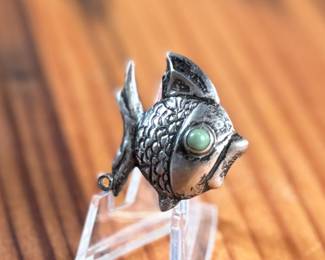 This lot features a vintage Taxco sterling silver “fish” pin.

