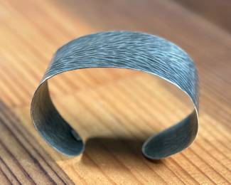 This lot features a cuff bracelet by designer, Marjorie Baer. Signed as shown in photos and measures, 7”.

