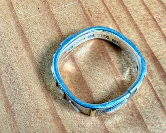 This lot features a hand made ring by maker, Armstrong. The ring is crafted from sterling silver and 22k gold. This ring comes in a size 10, a broken band as shown in photos, and a total approx. weight of 5.66 grams.

