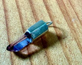 This lot features a 14k gold and amethyst pendant with a total approx. weight of 1.45 grams.

