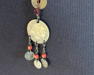 This lot features a Chinese necklace with red coral beads & coins. The necklace measures, 26”.

