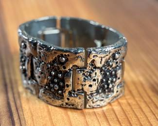 This lot features a brutalist style bracelet by designer Robert Larin, circa 1970s. This piece measures, 7” and is signed as shown in photos.

