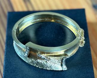 This lot features an incredible hand made 18k gold & diamond Art-Deco bangle bracelet with an integrated box clasp and safety chain. Accompanied with an appraisal from Reliant Gem Lab, this bracelet has a total approx. weight of 41.71 grams and .23 ct of thirteen (13) bead set single cut diamonds. 

