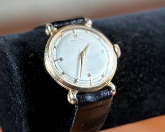 This lot features a vintage Hamilton "Fleetwood" manual-wind wristwatch in a 14k yellow gold case and black leather strap. Winds and runs. 36.5mm lug to lug.

