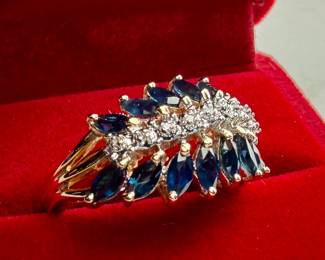 This lot features a stunning 14k gold two-tone diamond & sapphire ring. Accompanied with an appraisal, this ring comes in a size 7.75 and a total approx. weight of 4.6 grams. This ring contains fourteen (14) marquise cut sapphires and nine (9) single cut diamonds.

