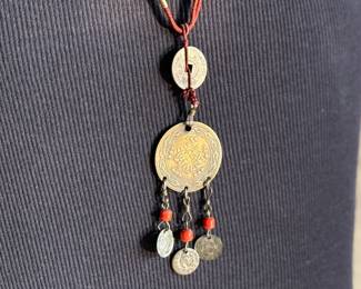 This lot features a Chinese necklace with red coral beads & coins. The necklace measures, 26”.

