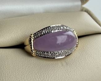 This lot features a 14k gold ring with lavender jadeite and genuine diamonds. The jadeite measures 17.7mm x 7.7mm and is set between two rows of single point diamonds. This ring comes in a size 7 with a total approx. weight of 4.42 grams.

