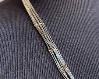 This lot features a stunning liquid silver and 14k gold necklace measuring, 23” with a total approx. weight of 27.57 grams.

