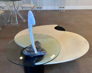 Post modern Roger Rougier coffee table. Pearlized white lacquer finish, black column-style legs, and pivoting glass top. 60x52x16 inches.