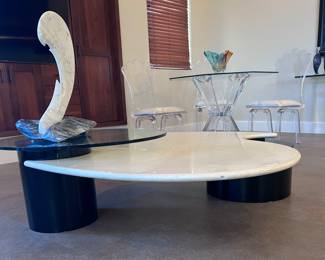 Post modern Roger Rougier coffee table. Pearlized white lacquer finish, black column-style legs, and pivoting glass top. 60x52x16 inches.