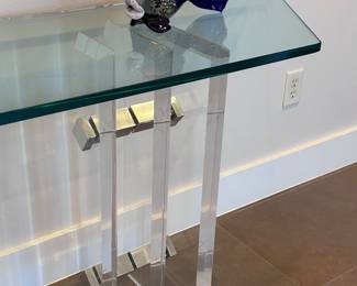 After Charles Hollis Jones Post Modern Acrylic/Lucite and glass console table. Beautiful, thick “skyscraper” lucite base with metal detail and 3/4 inch glass top. 82x18x22.5 inches.