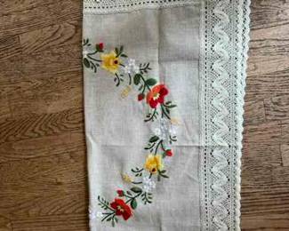 square linen cloth with embroidered floral wreath and wide lace trim