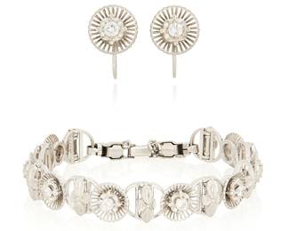 1020
A White Gold-Filled and Diamond Bracelet and Earring Set
Featuring an openwork floral design set with round diamonds weighing approximately 1.00 carat total
3 pieces

Bracelet: 6 1/2 in., Earrings: 1/2 x 3/8 in.
28.8 grams gross
Estimate: $300 - $500

